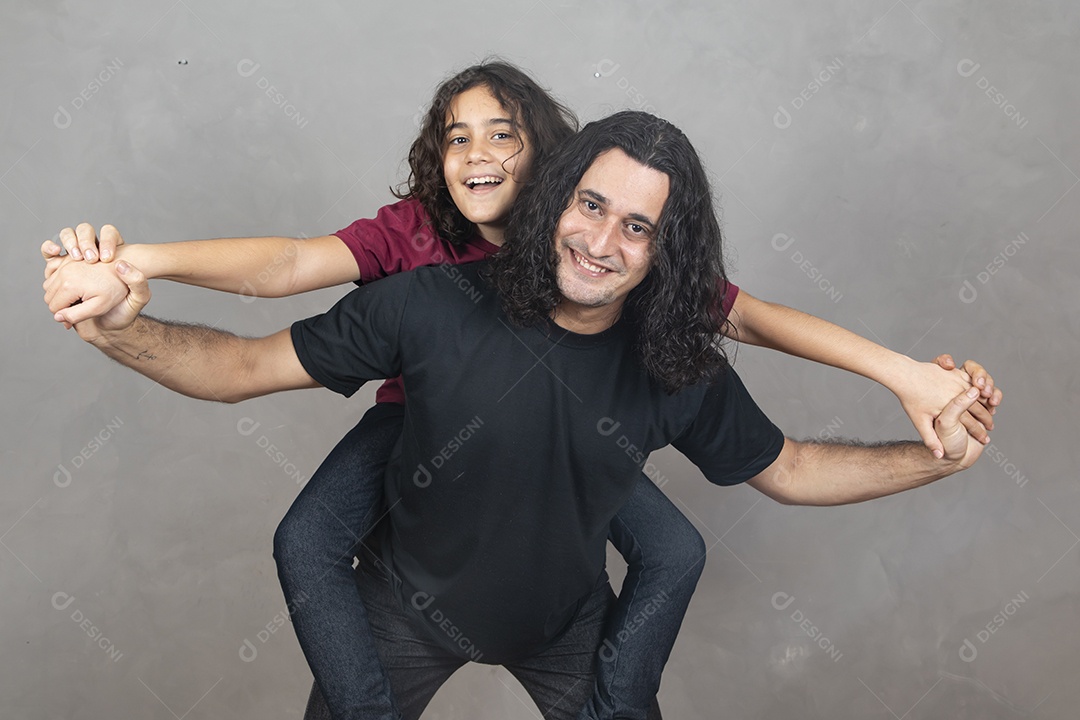 Pai com sua filha nas sua costas sobre fundo cinza