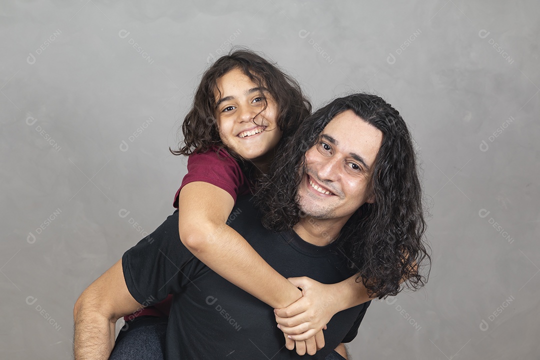 Pai com sua filha nas sua costas sobre fundo cinza