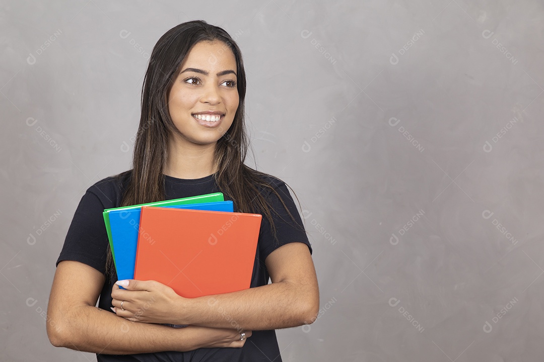 Linda mulher jovem garota sorridente segurando materiais escolar sobre fundo isolado cinza