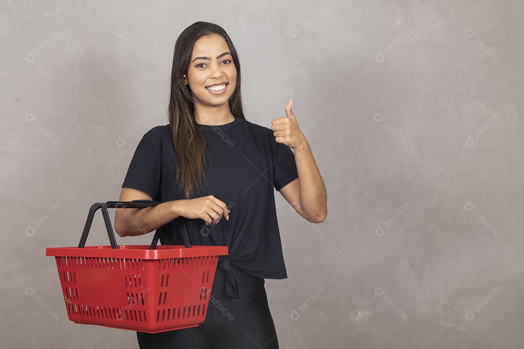 Linda mulher jovem garota segurando cesta de compras mercado sorridente sobre fundo isolado cinza