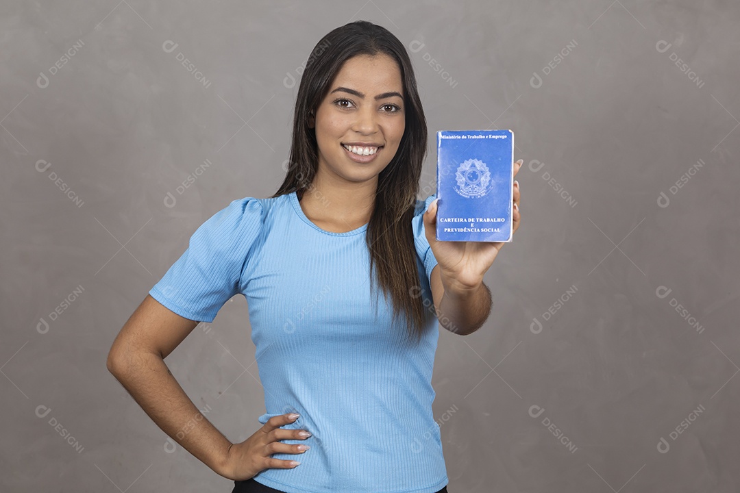 Mulher jovem sorridente segurando uma carteira de trabalho
