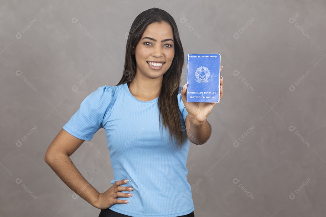 Mulher jovem sorridente segurando uma carteira de trabalho