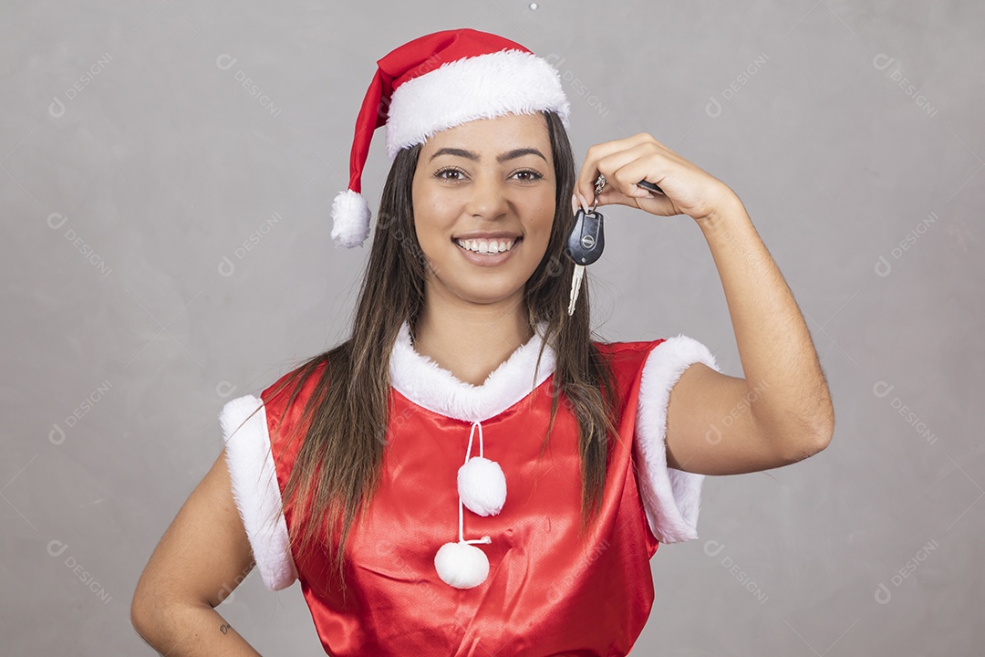 Mulher jovem vestida de Papai Noel segurando um chave de uma automóvel