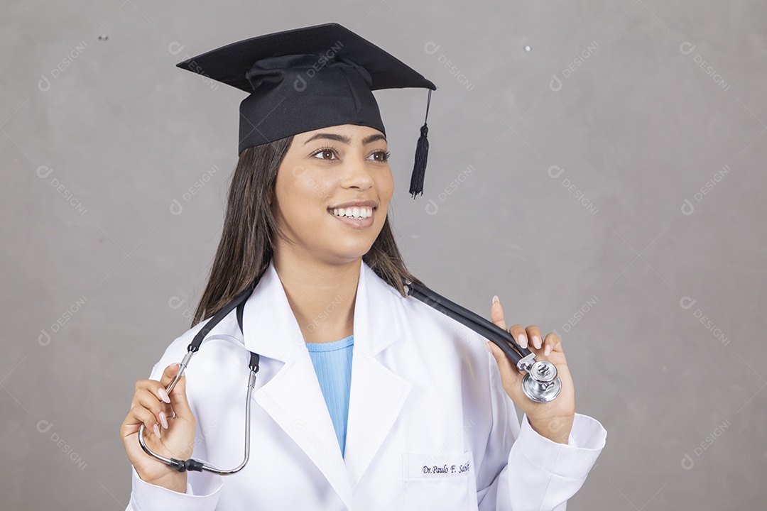 Mulher jovem se formando em medicina vestindo jaleco branco e boina