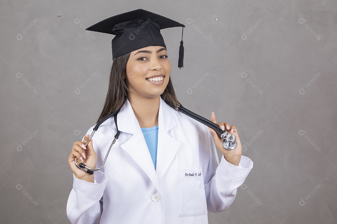 Mulher jovem se formando em medicina vestindo jaleco branco e boina