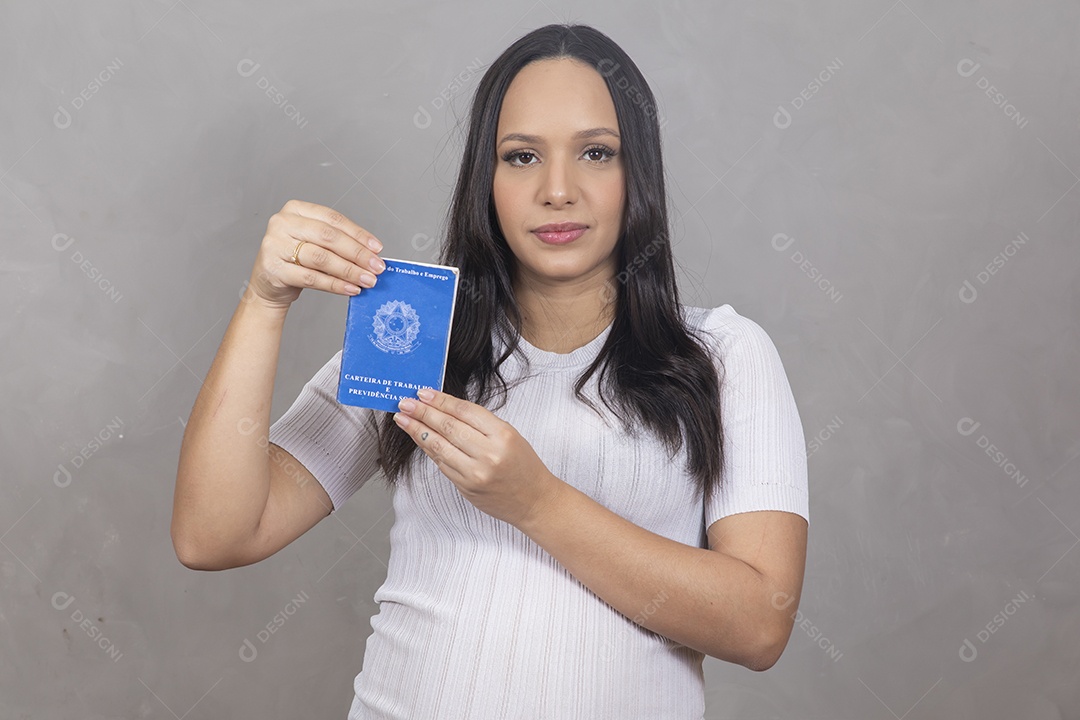 Mulher jovem gravida segurando uma carteira de trabalho