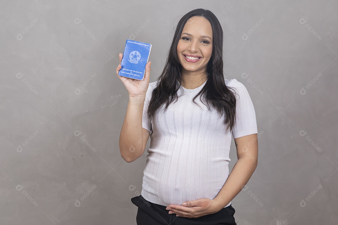 Mulher jovem gravida segurando uma carteira de trabalho