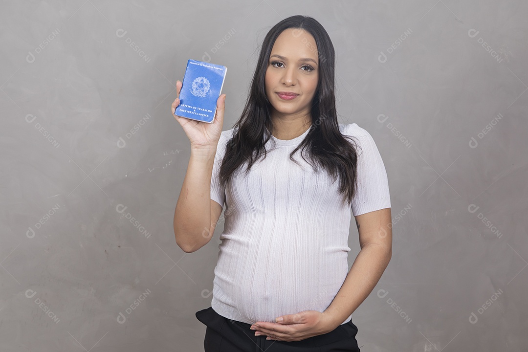 Mulher jovem gravida segurando uma carteira de trabalho