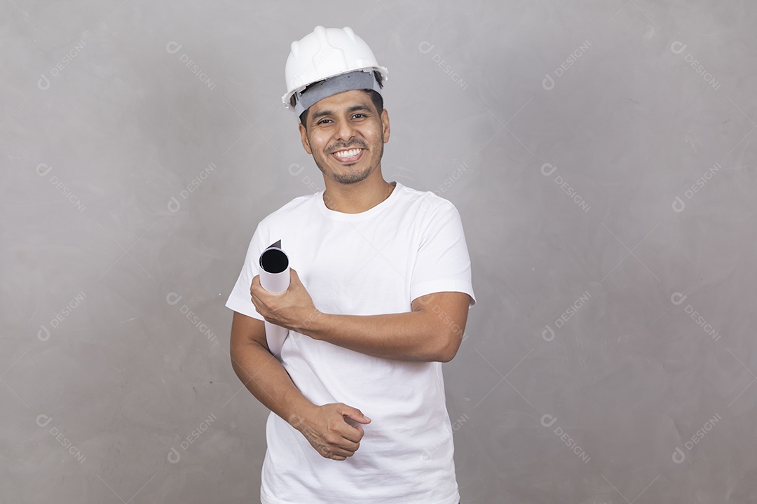 Homem jovem engenheiro usando capacete branco garoto sorridente sobre fundo isolado cinza