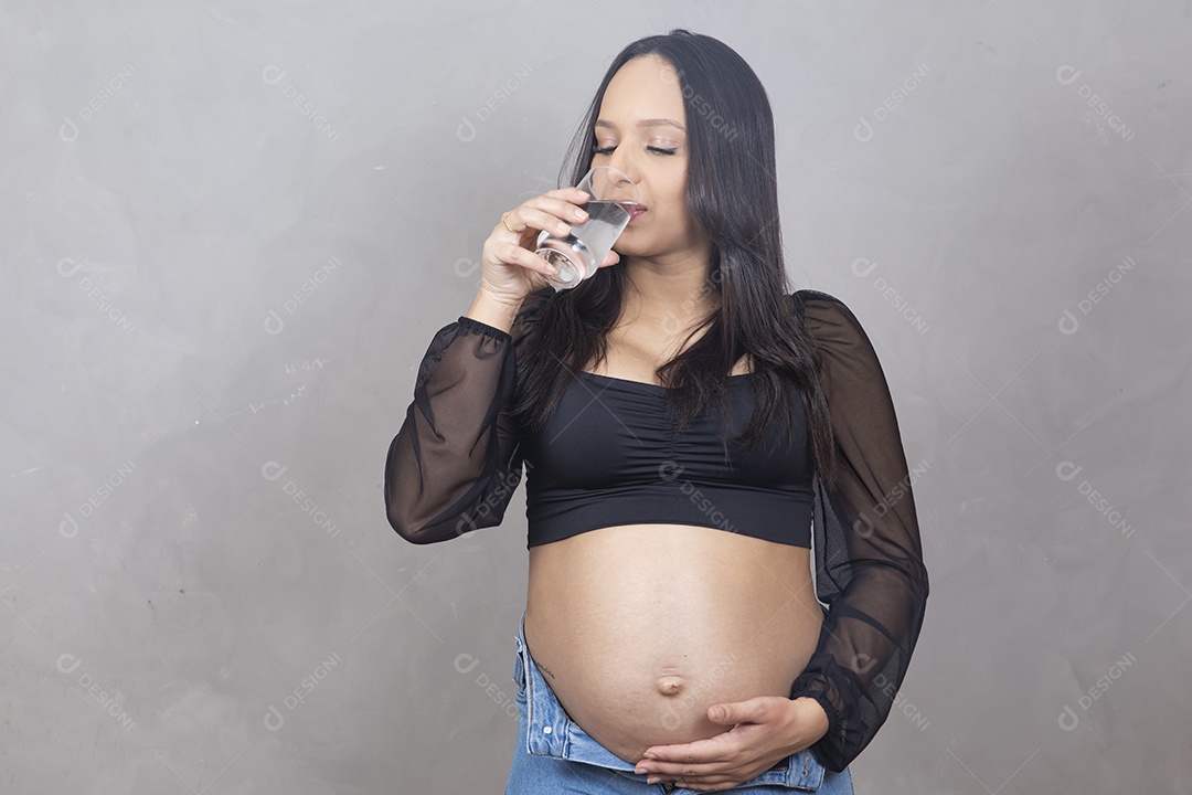 Linda mulher bebendo agua gravida feliz por sua gravidez se hidratando