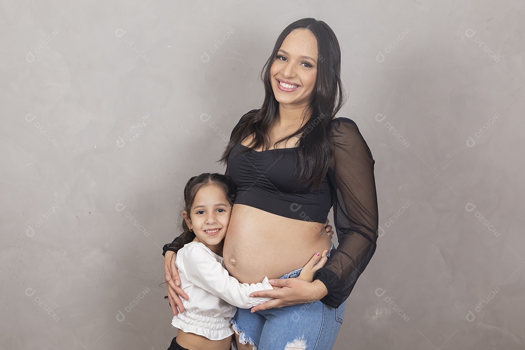 Linda mulher gravida feliz por sua gravidez com sua filha abraçando sua barriga