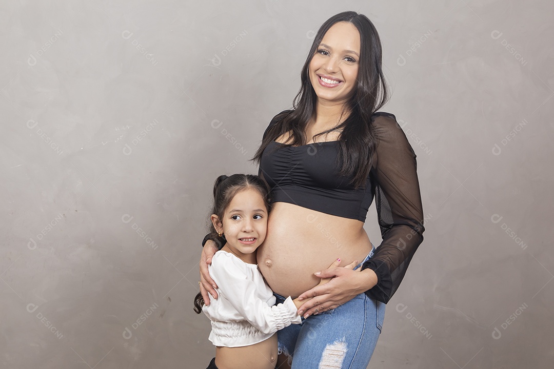 Linda mulher gravida feliz por sua gravidez com sua filha abraçando sua barriga