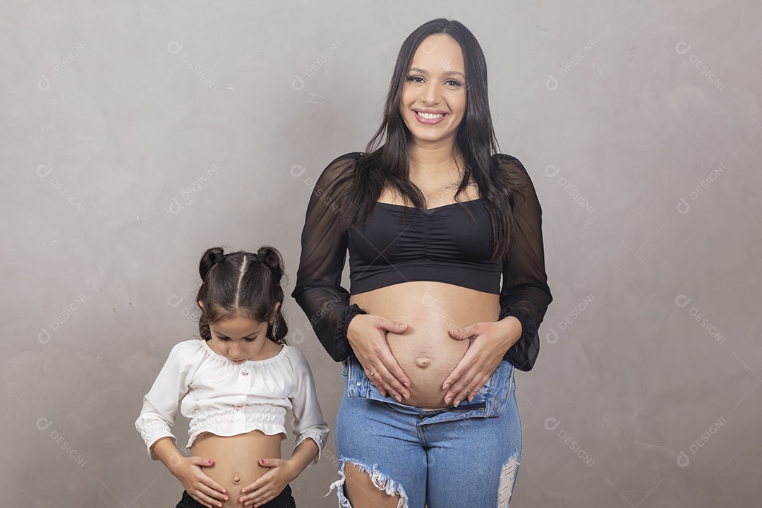 Linda mulher gravida feliz por sua gravidez com sua filha abraçando sua barriga