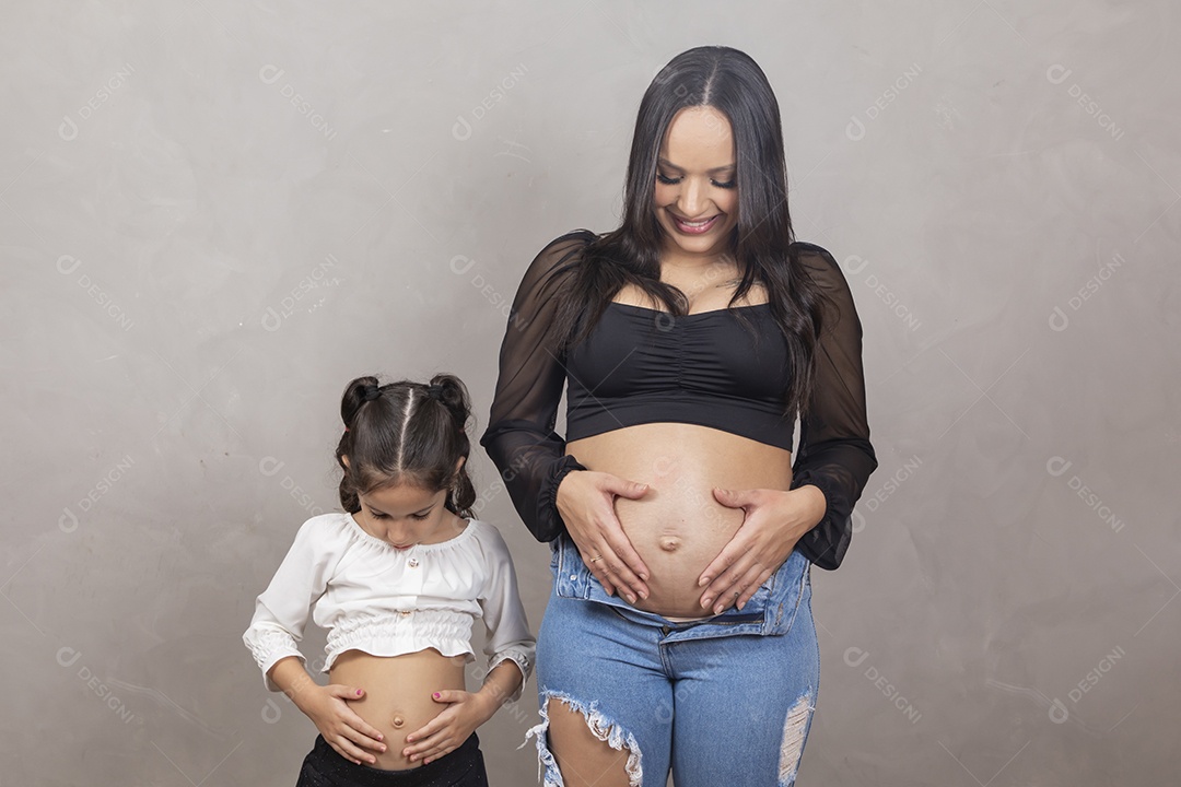 Linda mulher gravida feliz por sua gravidez com sua filha abraçando sua barriga