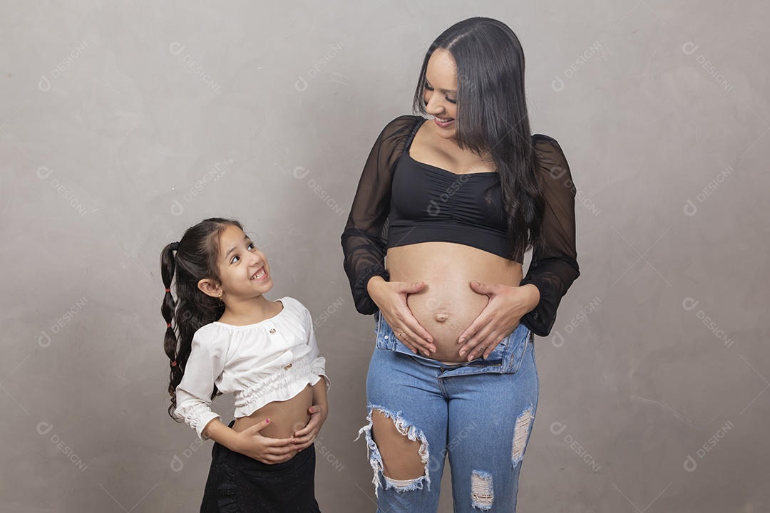 Linda mulher gravida feliz por sua gravidez com sua filha abraçando sua barriga