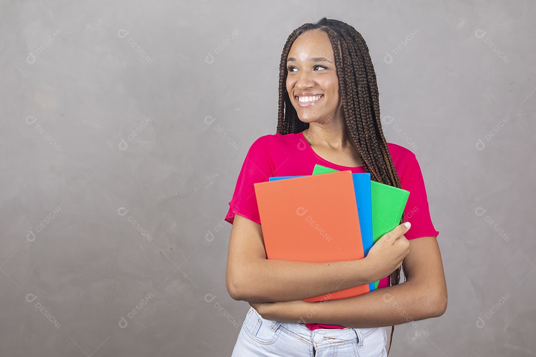 Linda mulher jovem garota sorridente segurando materiais escolar sobre fundo isolado cinza