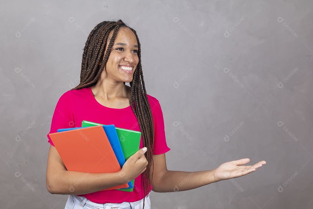 Linda mulher jovem garota sorridente segurando materiais escolar sobre fundo isolado cinza