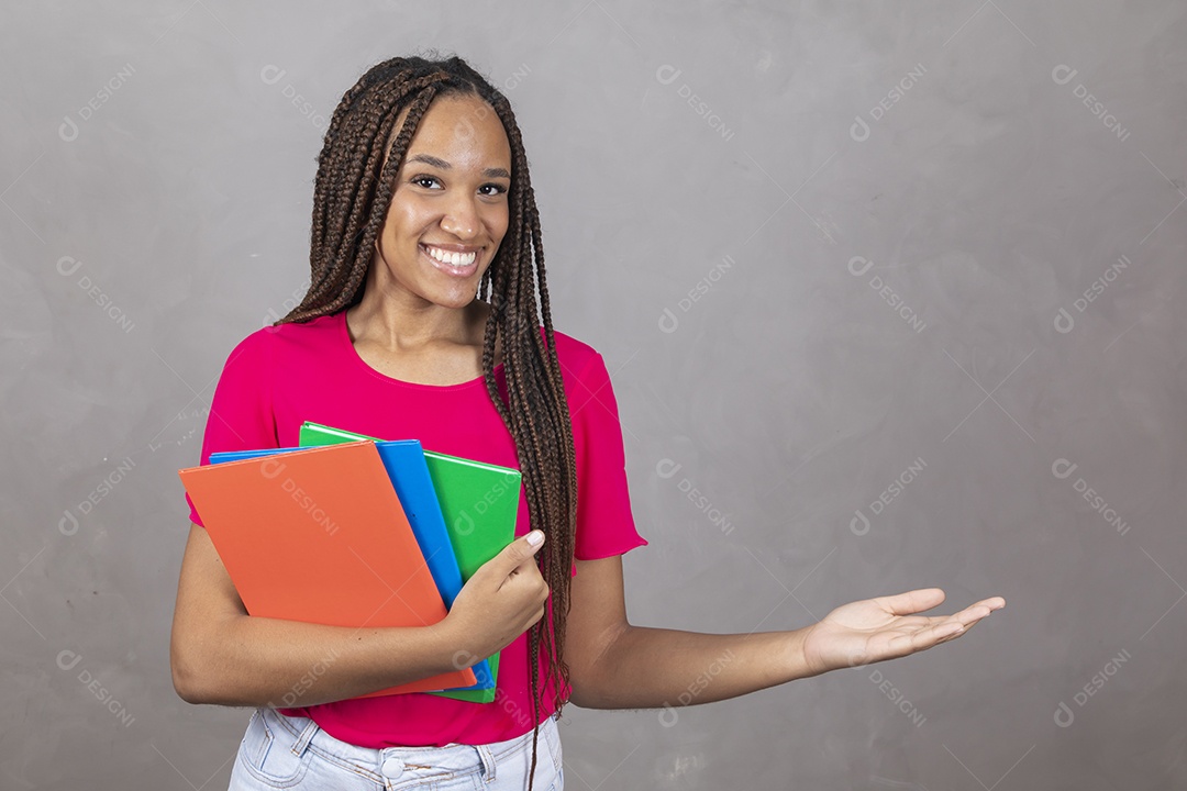 Linda mulher jovem garota sorridente segurando materiais escolar sobre fundo isolado cinza
