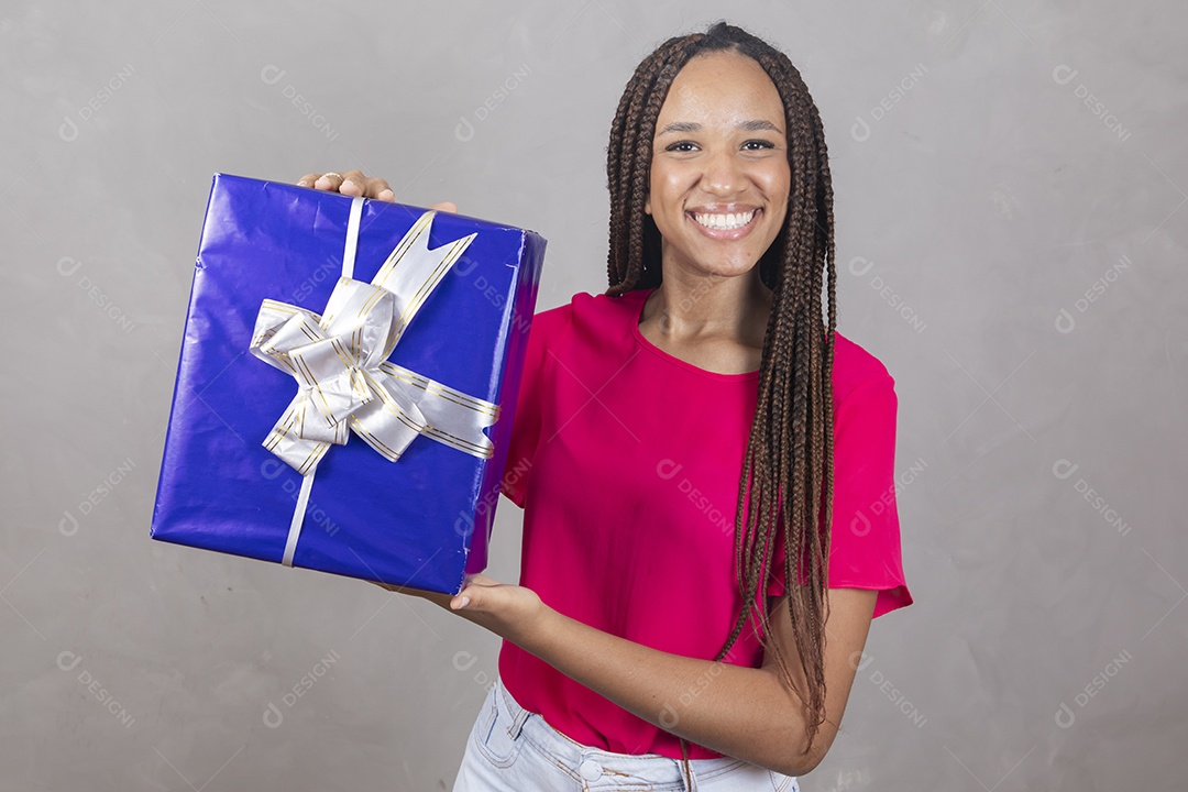 Linda mulher jovem garota sorridente segurando presente sobre fundo isolado cinza