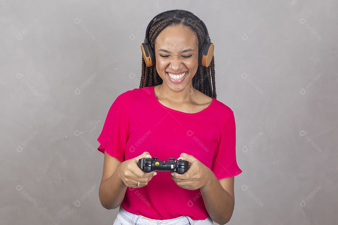 Linda mulher jovem garota sorridente jogando videogame sobre fundo isolado cinza