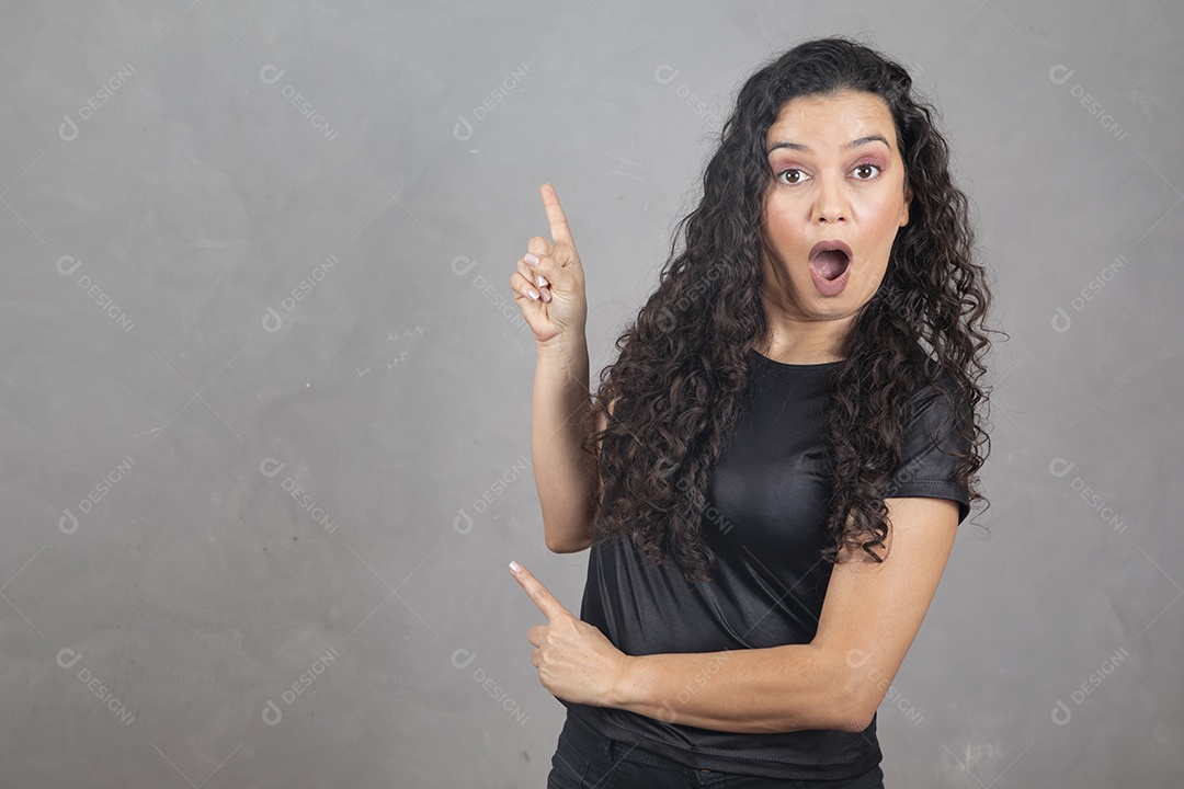 Linda mulher jovem garota sorridente apontando para lado sobre fundo isolado cinza