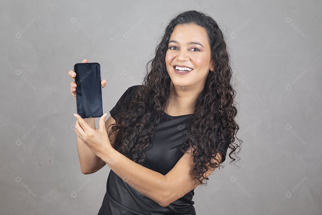 Linda mulher jovem garota sorridente segurando celular sobre fundo isolado cinza