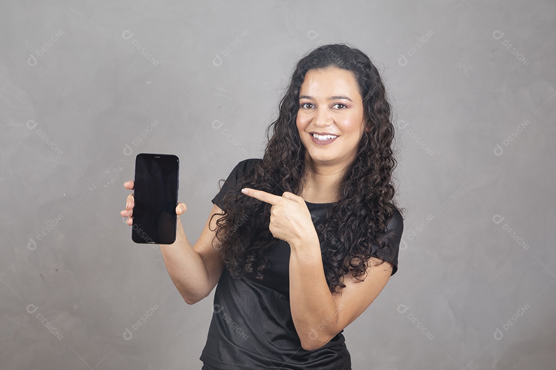 Linda mulher jovem garota sorridente segurando celular sobre fundo isolado cinza