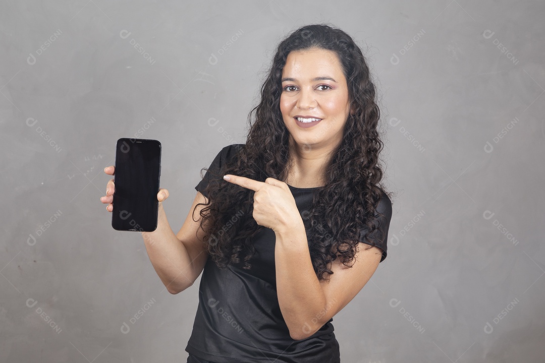 Linda mulher jovem garota sorridente segurando celular sobre fundo isolado cinza