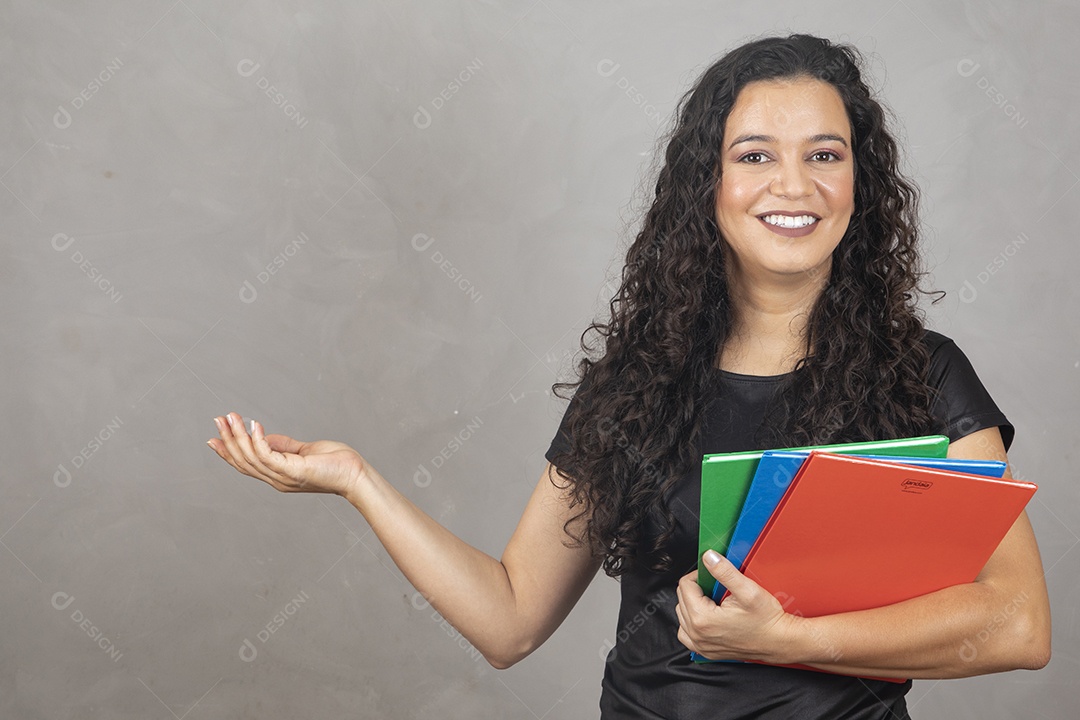 Linda mulher jovem garota sorridente segurando matérias escolar sobre fundo isolado cinza