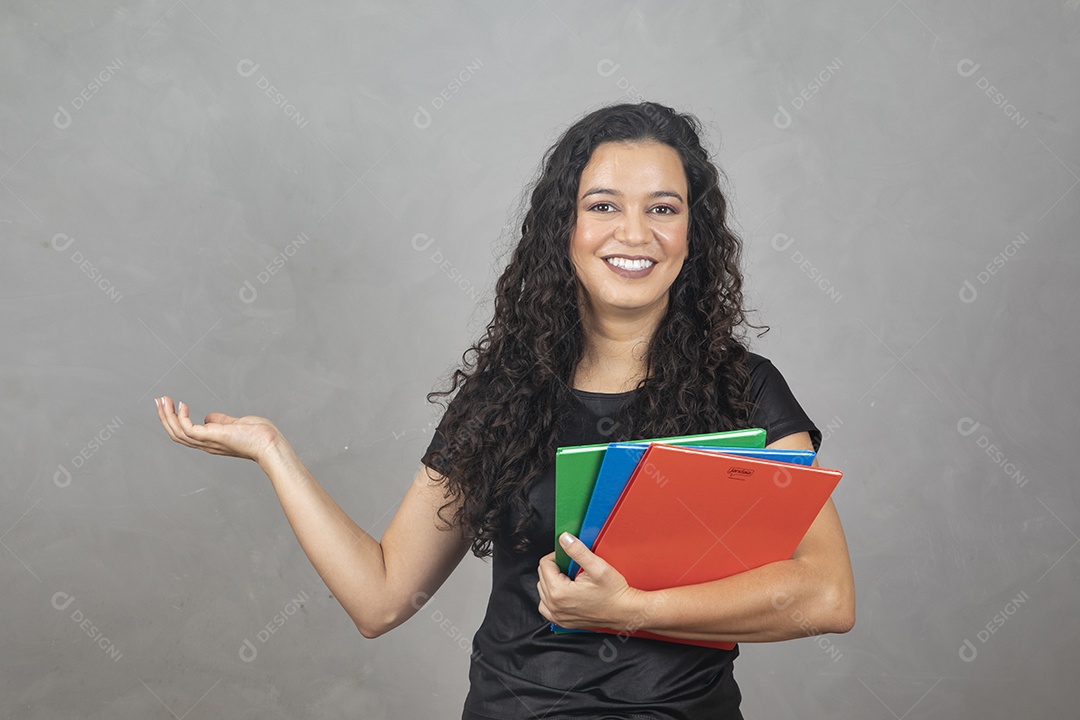 Linda mulher jovem garota sorridente segurando matérias escolar sobre fundo isolado cinza