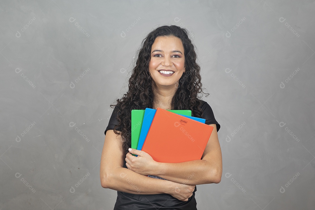 Linda mulher jovem garota sorridente segurando matérias escolar sobre fundo isolado cinza