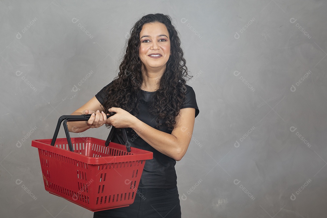 Linda mulher jovem garota sorridente segurando cesta de mercado compras sobre fundo isolado cinza