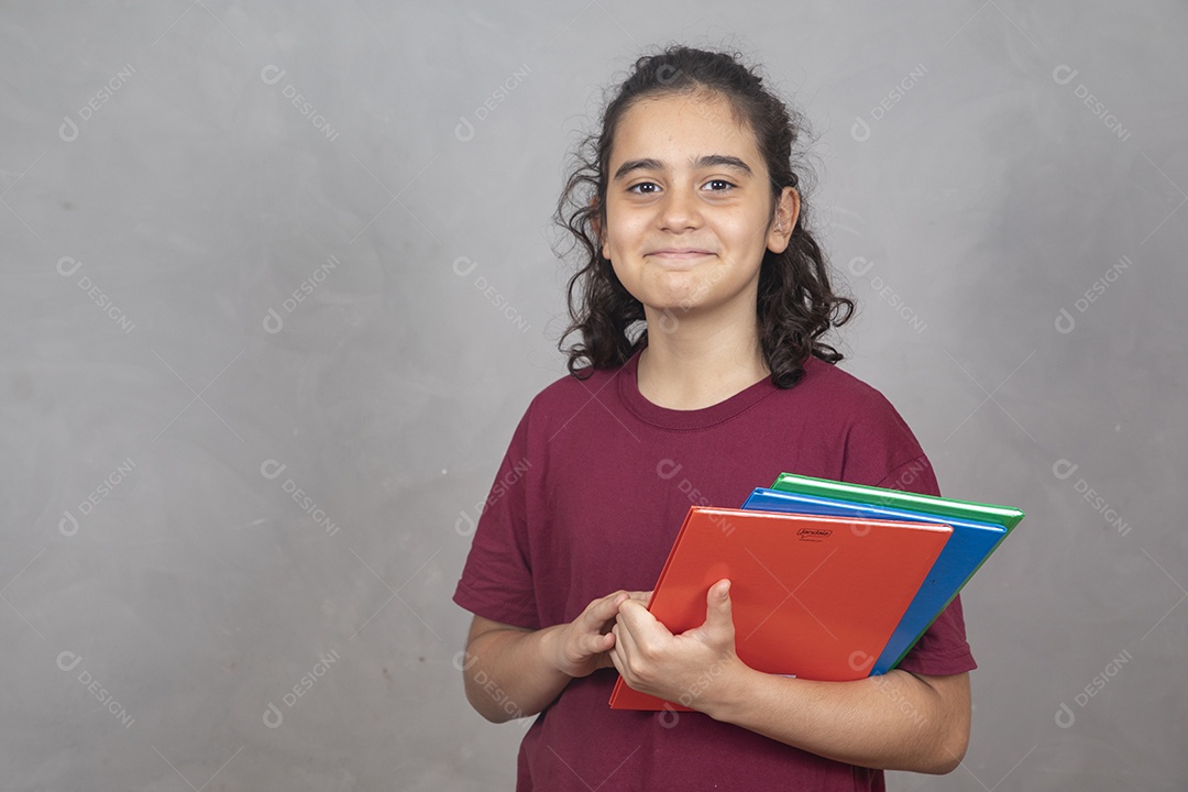 Menino estudante segurando materiais escolar