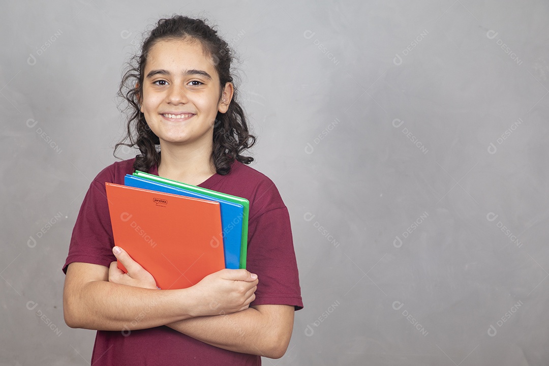 Menino estudante segurando materiais escolar