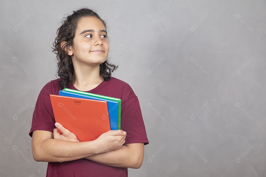 Menino estudante segurando materiais escolar