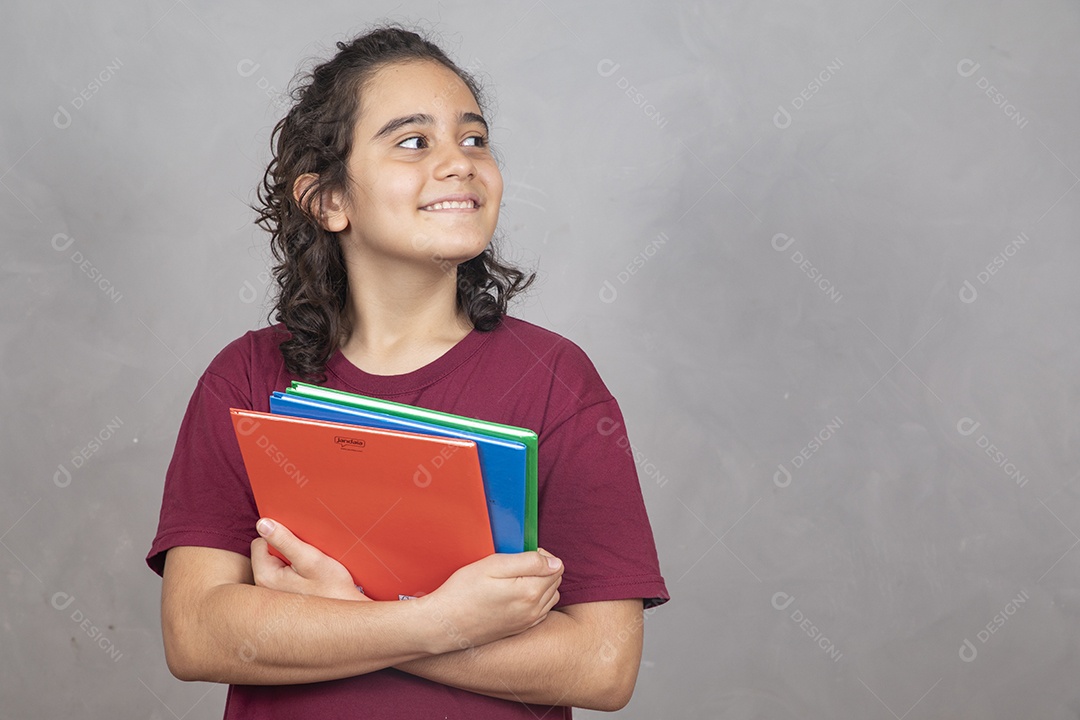 Menino estudante segurando materiais escolar