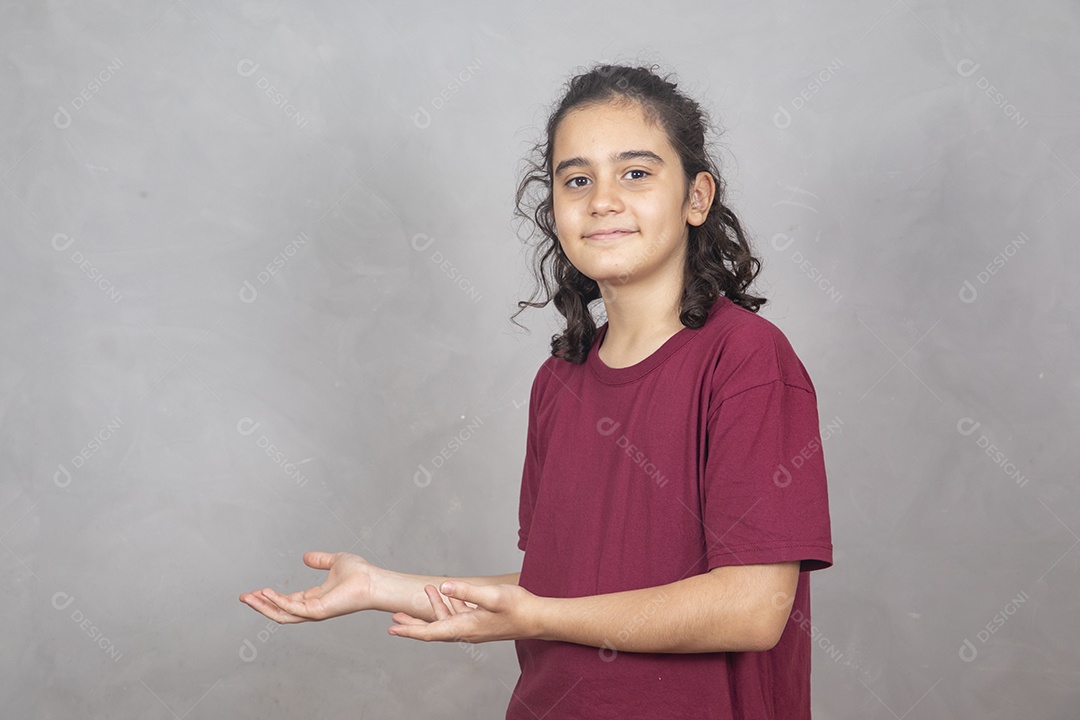 Menino criança garoto sobre fundo cinza apontando para lado