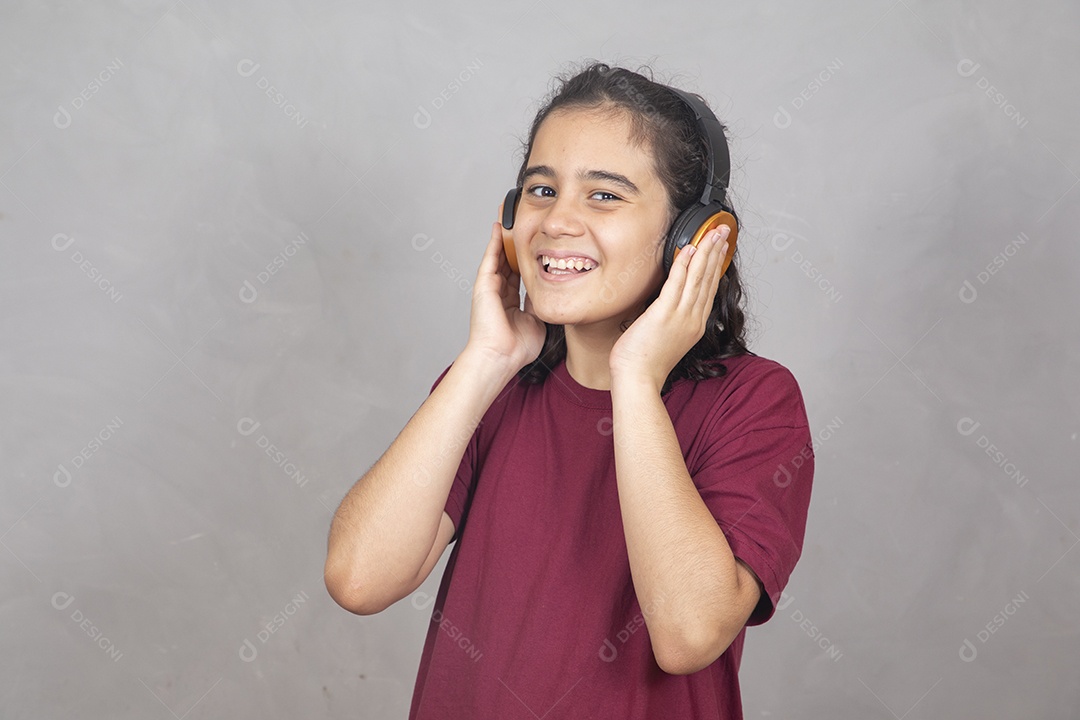 Menino criança garoto sobre fundo cinza usando fones de ouvido