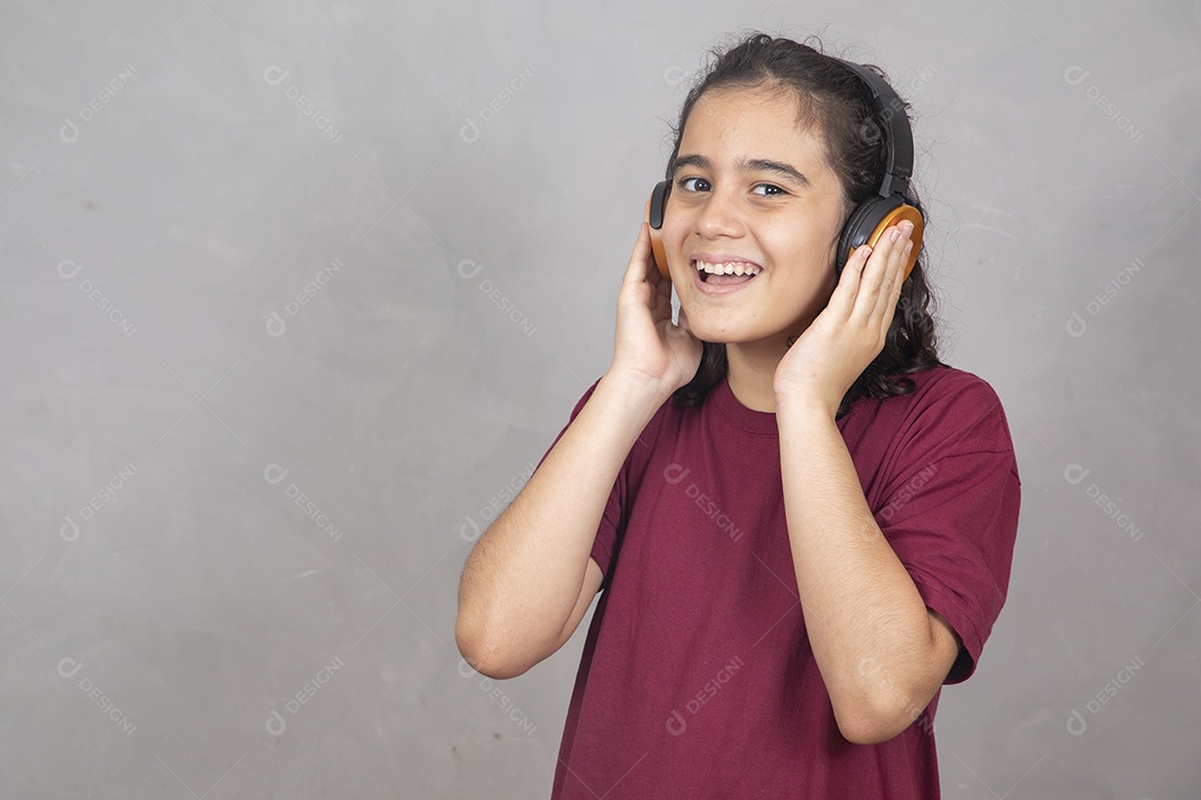 Menino criança garoto sobre fundo cinza usando fones de ouvido