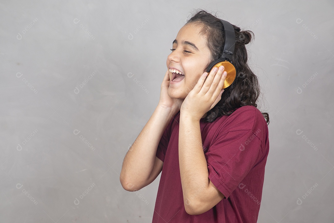 Menino criança garoto sobre fundo cinza usando fones de ouvido