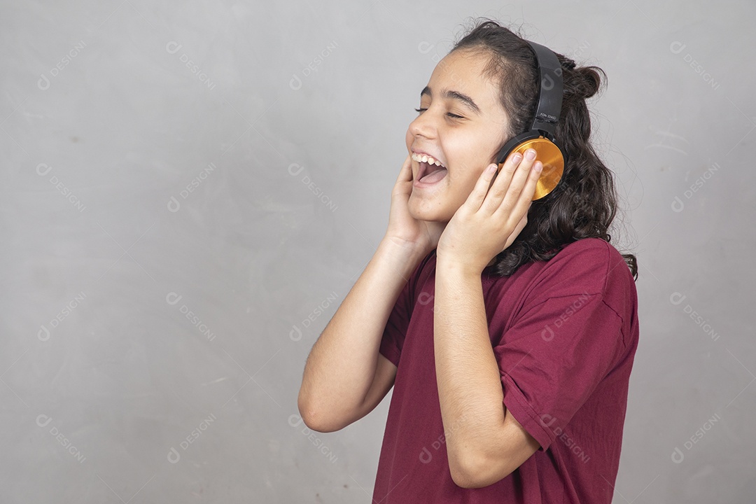 Menino criança garoto sobre fundo cinza usando fones de ouvido