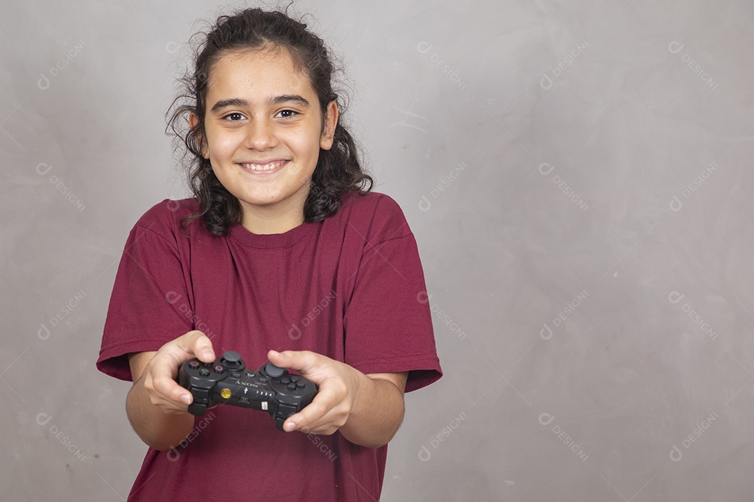 Menino criança garoto sobre fundo cinza jogando videogame