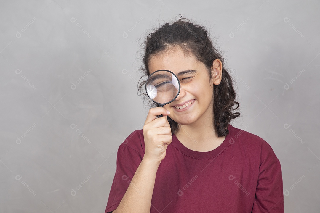 Menino criança garoto sobre fundo cinza usando lupa