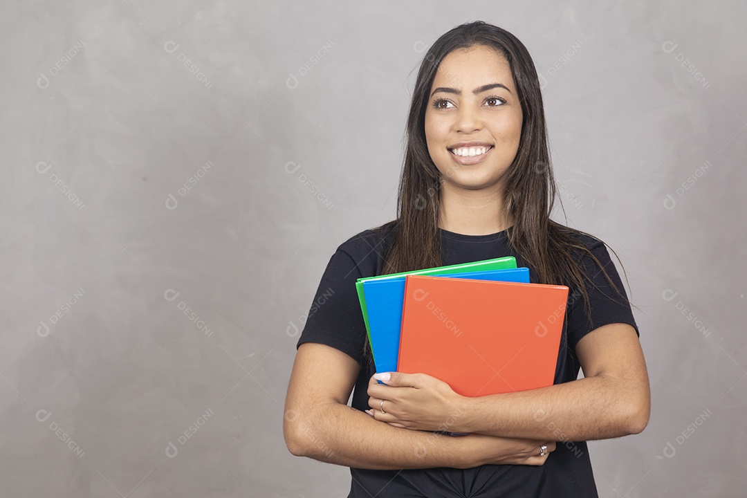 Linda mulher jovem garota sorridente segurando materiais escolar sobre fundo isolado cinza