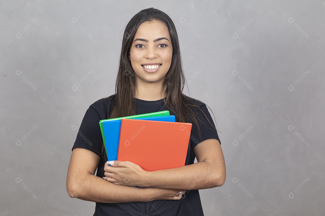 Linda mulher jovem garota sorridente segurando materiais escolar sobre fundo isolado cinza