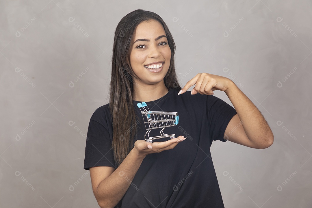 Linda mulher jovem garota segurando carrinho de compras mercado sorridente sobre fundo isolado cinza