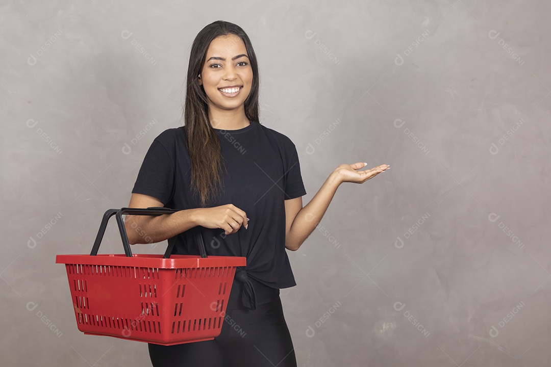 Linda mulher jovem garota segurando cesta de compras mercado sorridente sobre fundo isolado cinza