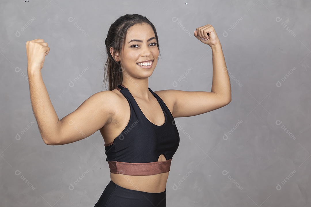 Linda mulher jovem garota fazendo gesto de Double bíceps sorridente sobre fundo isolado cinza