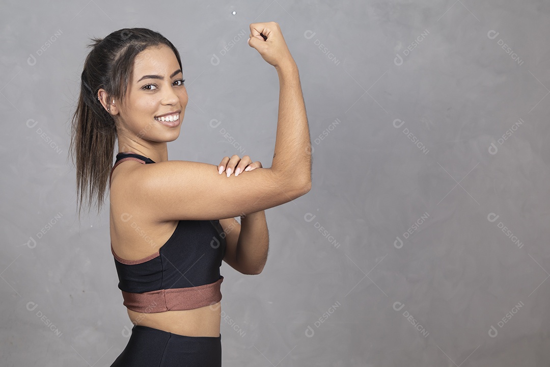 Linda mulher jovem garota fazendo gesto de Double bíceps sorridente sobre fundo isolado cinza
