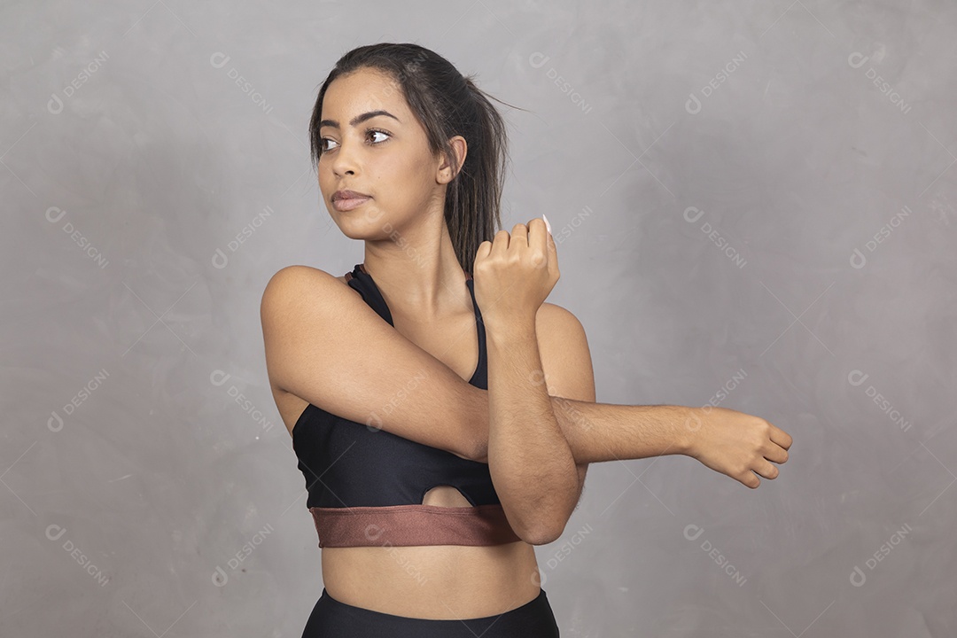Linda mulher jovem garota sorridente  se alongando exercícios sobre fundo isolado cinza